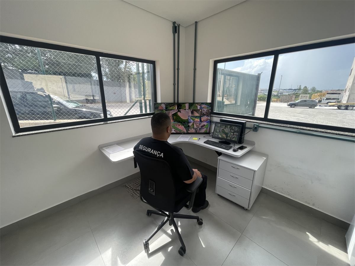 Profissional de segurança acompanhando imagens em uma central de monitoramento